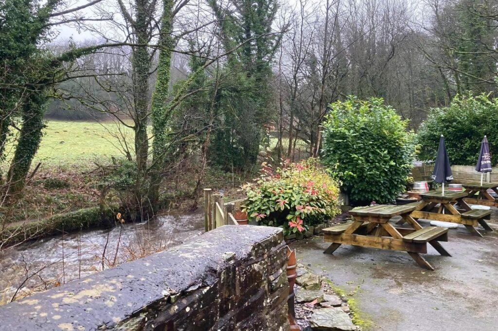 Riverside view of the outdoor garden at The Black Horse Pub